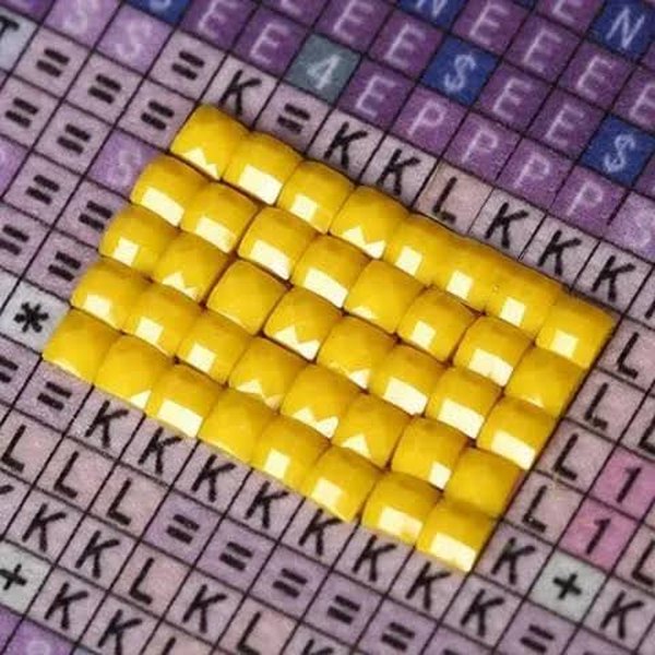Gemas colocadas sobre la cuadrícula numerada del lienzo